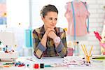 Portrait of thoughtful seamstress in studio