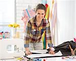 Portrait of happy seamstress working in studio