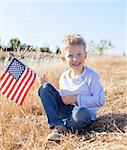 cute little boy holding american flag and celebrating independence day
