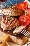 Juicy beef steak with tomato salad served on an old wooden cutting board.