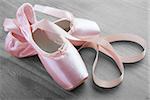 new pink ballet pointe shoes on vintage wooden background