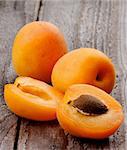 Two Ripe Full Body Apricots and Halves isolated on Rustic Wooden background