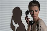 charming woman with vintage style and elegant hair-style talking on the retro phone, taking receiver near the face