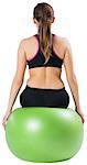 Fit brunette sitting on exercise ball on white background