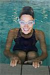 Fit swimmer smiling up at camera in the swimming pool at the leisure center