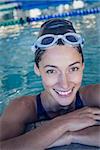 Fit swimmer smiling at camera in the swimming pool at the leisure center