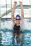 Excited swimmer cheering in the swimming pool at the leisure center