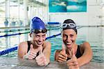 Female swimmers smiling at camera in the swimming pool at the leisure center