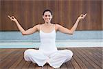 Peaceful happy woman in white sitting in lotus pose in health spa