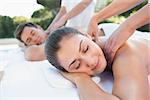 Attractive couple enjoying couples massage poolside outside at the spa