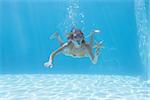 Cute blonde underwater in the swimming pool with snorkel and starfish on their holidays