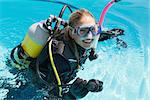 Smiling woman on scuba training in swimming pool on a sunny day