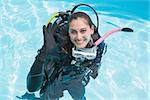 Smiling woman on scuba training in swimming pool making ok sign on a sunny day