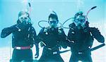 Friends on scuba training submerged in swimming pool making ok sign on their holidays