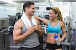Bodybuilding man and woman chatting together at the gym
