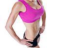 Female bodybuilder posing in pink sports bra mid section on white background