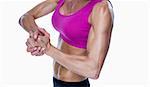 Female bodybuilder posing with hands together on white background