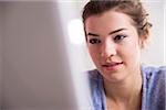 Close-up of young woman working in office on desktop PC, Germany