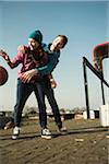 Teenage boy and girl playing basketball outdoors, industrial area, Mannheilm, Germany