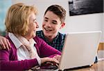 Teenage boy with grandmother working on notebook computer, Germany