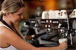 Young female waitress preparing coffee in cafe