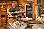 Mature man holding tray of fresh pastries