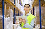 Female warehouse worker using digital tablet