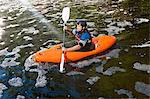 Mid adult man kayaking on peaceful river