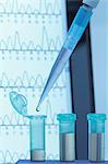 Genetic research. Micropipette filling eppendorf microcentrifuge tubes, commonly used in biochemical and biological research. Laptop screen that displays results of automated DNA sequencing