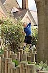 School boy stepping on log fence