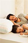 Father and young son asleep in bed