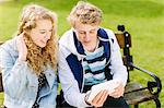 Teenage siblings looking at digital tablet on bench