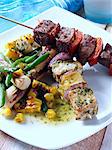 Pork and pineapple and chilli beef kebabs with corn and palm heart salad