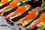 Still life of sliced avocado with fish and fish roe