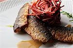 Still life of smoked fish with a stack of grated vegetable