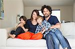 Portrait of family with two boys on sofa