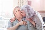Affectionate mature adult couple kissing at home