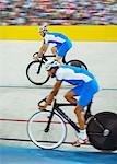 Track cyclists riding in velodrome