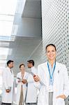 Portrait of confident doctor with clipboard in hospital corridor