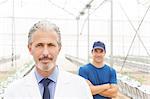 Portrait of confident scientist and worker in greenhouse