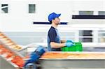 Worker carrying crate in food processing plant