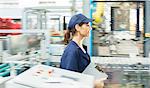 Worker with clipboard walking in food processing plant