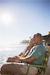 Senior couple relaxing in lawn chairs on beach