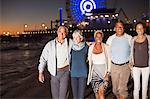 Senior friends walking on beach at night