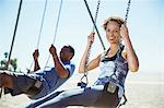 Couple on swings at beach