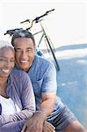 Portrait of smiling senior couple near bicycle