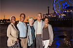 Portrait of senior friends on beach at night