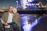 Senior couple hugging on beach at night