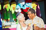 Senior couple eating ice cream cones at amusement park