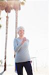 Senior woman power walking on beach boardwalk